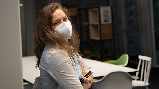 Katharina wearing a mask, looking at the camera.