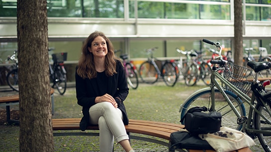 Katharina in a bike park, surrounded by bicycles