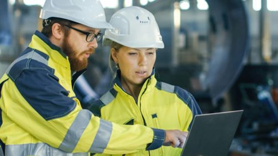 Dos ingenieros discutiendo mientras miran una computadora portátil.