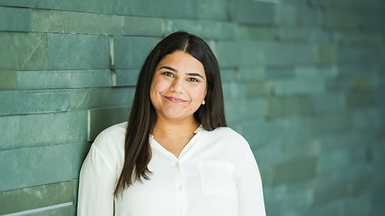 Frau steht vor einr grauen Wand 