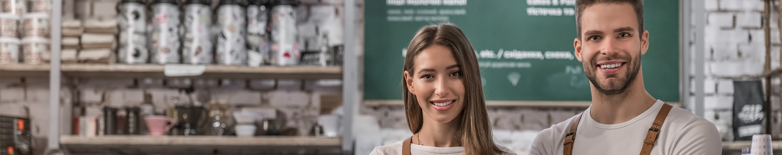 Zwei Menschen vor Regalen und einer Kaffeebar