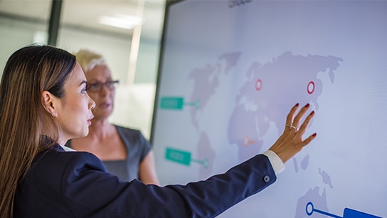 Zwei Menschen bei einer Besprechung vor einem Bildschirm 