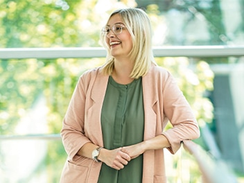 Frau steht vor einem grünen Hintergrund