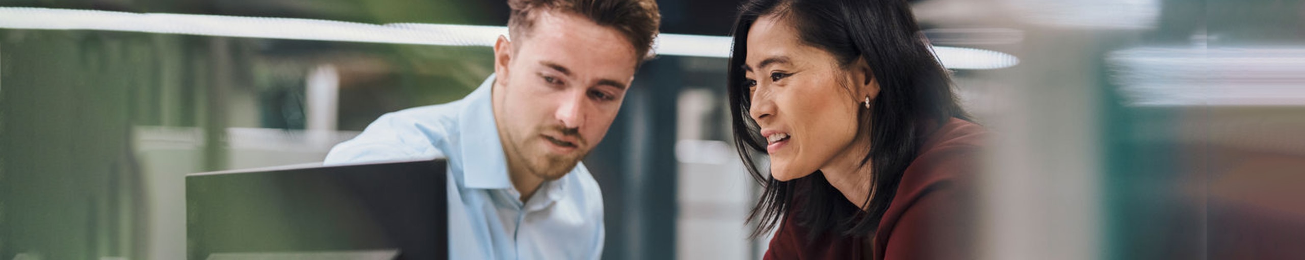 Two employees looking at computer desktop