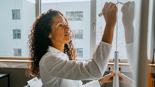 Woman writing on whiteboard