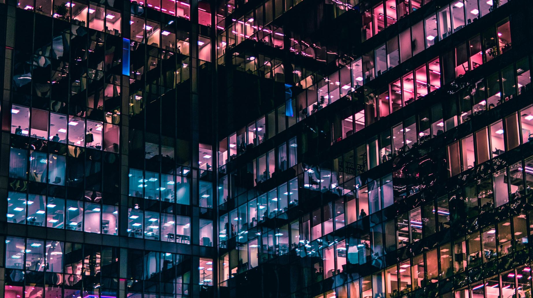 Modern office building with illuminated windows at night.