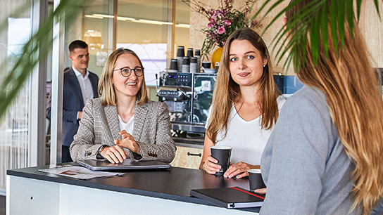 High school graduates are standing at a table and chatting.