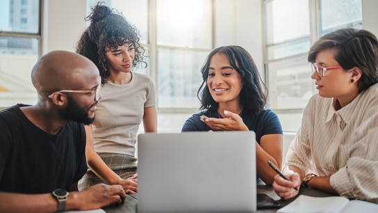 Colleagues engaged in a discussion while working on a laptop