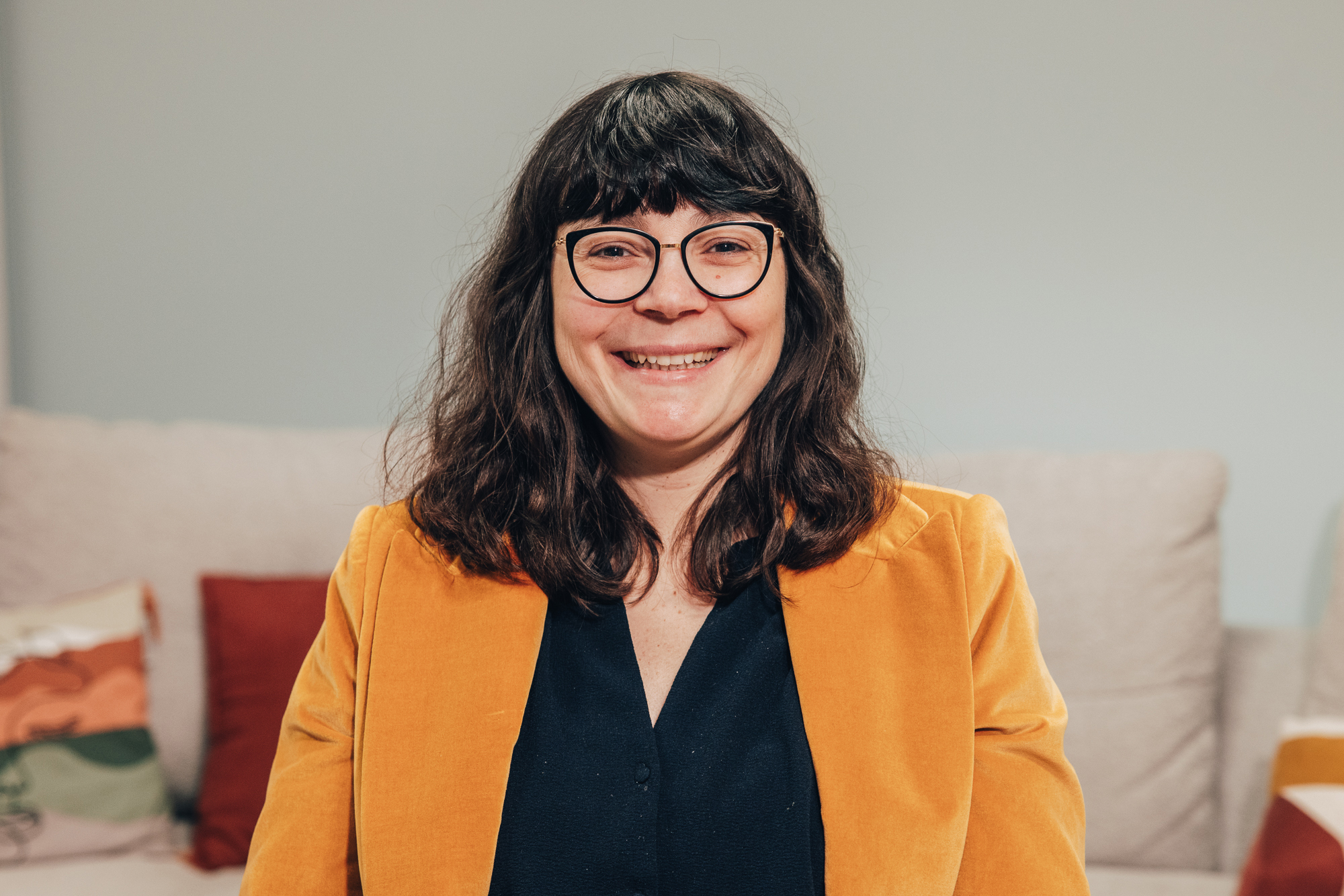 Allianz France Employee with orange blazer smiling at camera