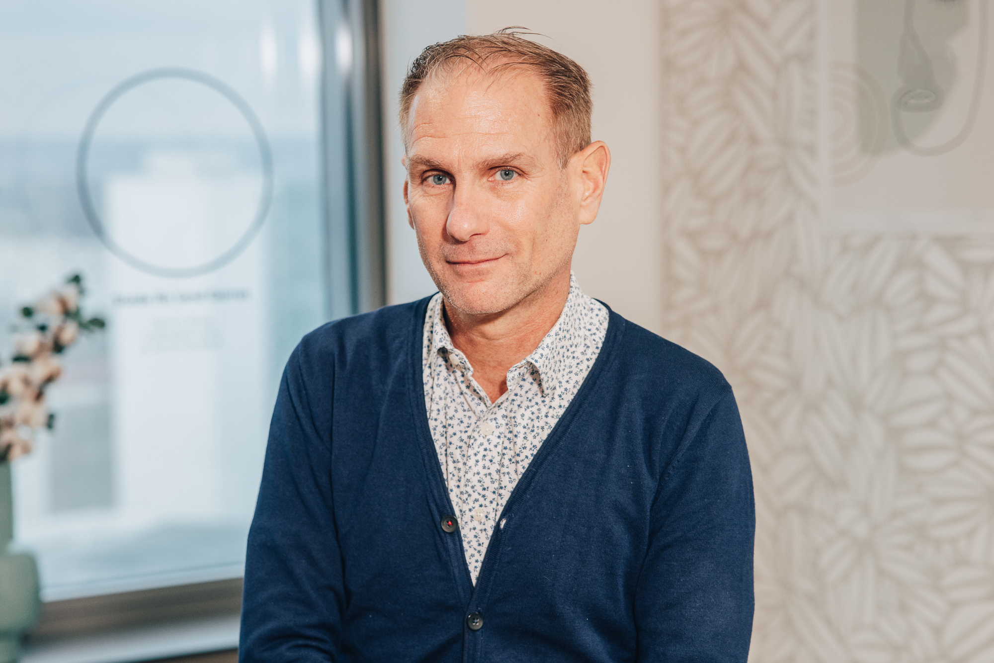 Allianz France Employee in blue cardigan sitting in front of camera