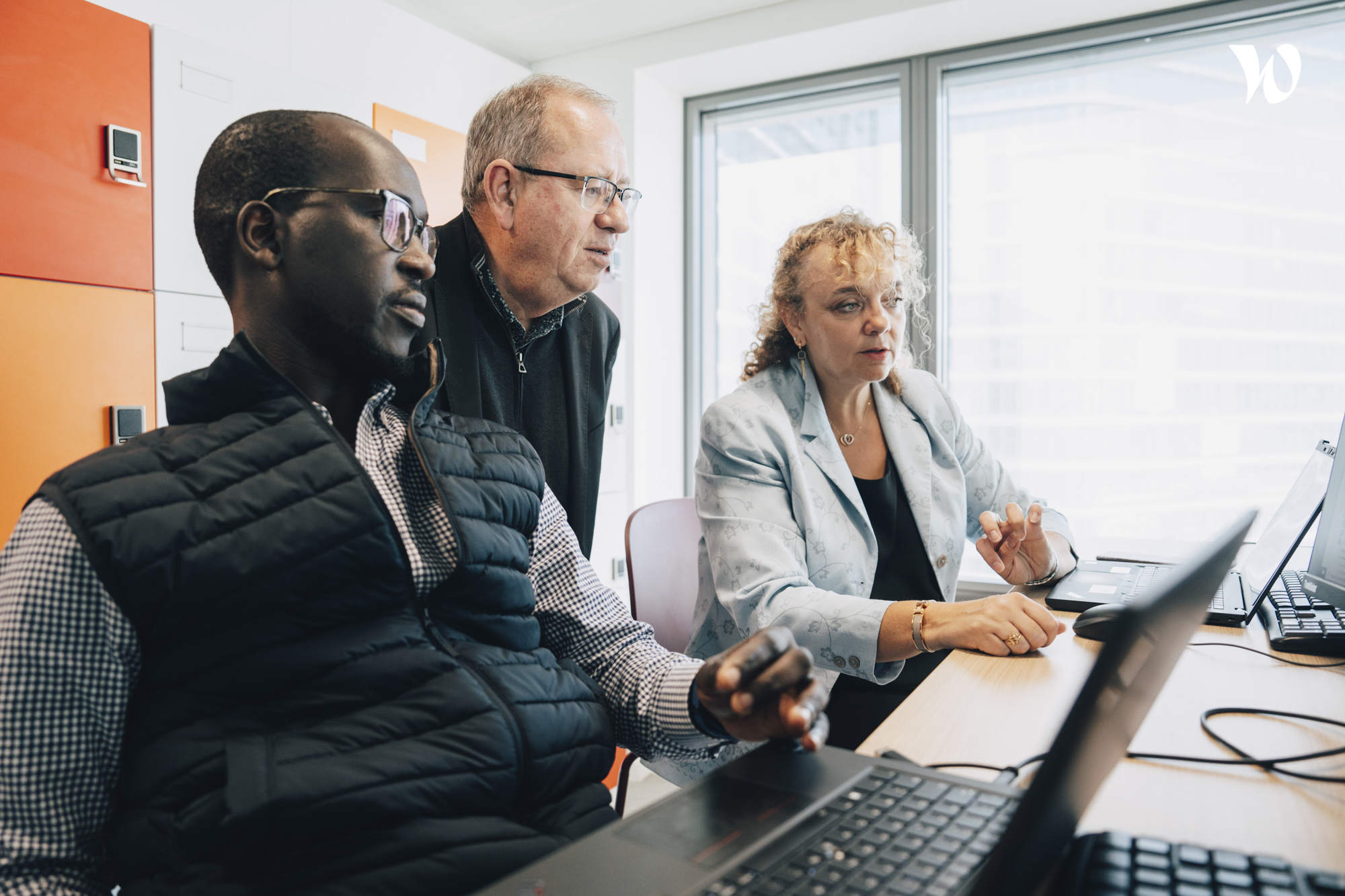 Three employees looking at Laptop