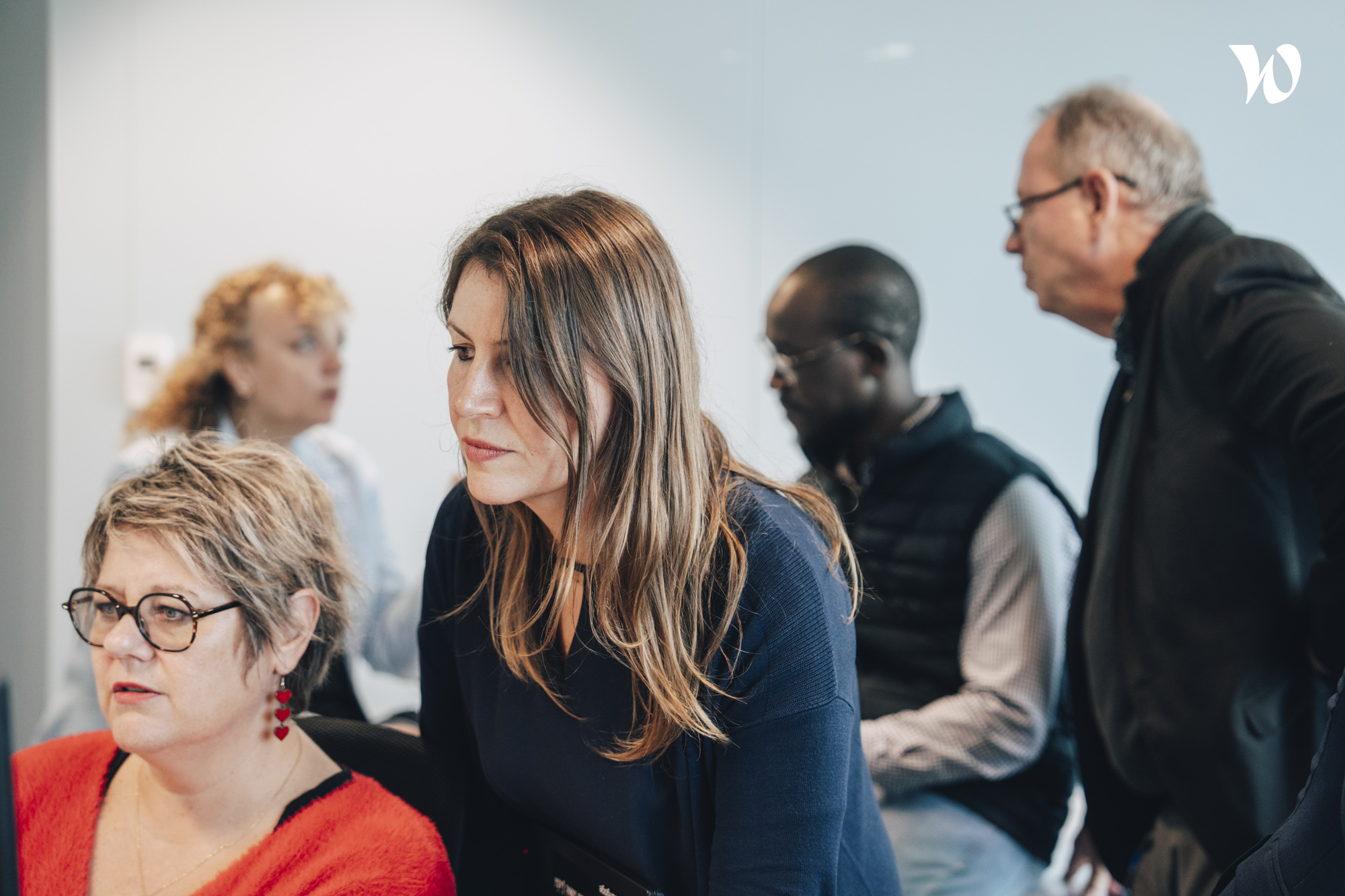 group of employees in a meeting room discussing topics