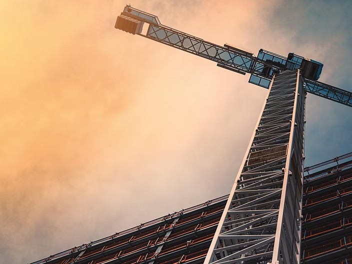 A construction crane elevated on a building, illustrating the dynamic nature of urban construction and development efforts