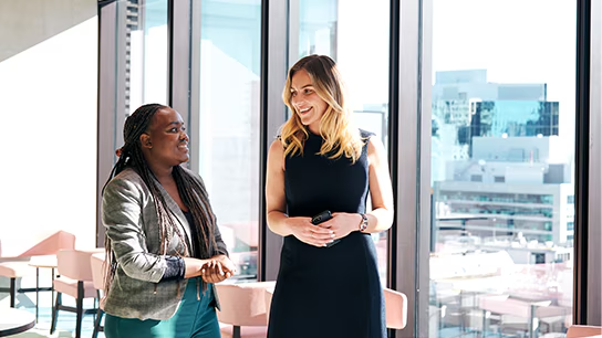 Two employees looking and smiling at each other showcasing diversity