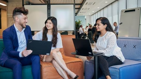 A group of people sitting in chairs with laptops