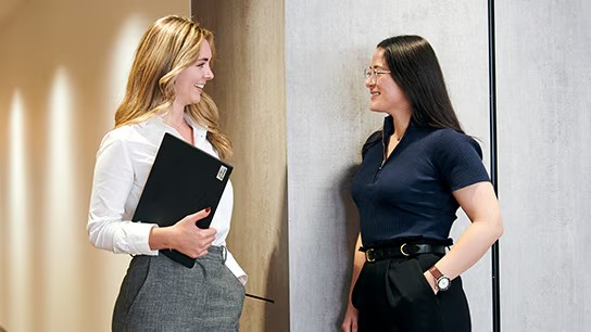 Two women in business suits standing side by side