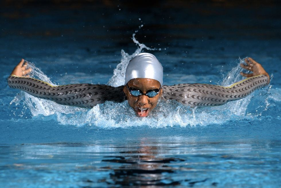 Malia glides through the water, arms outstretched