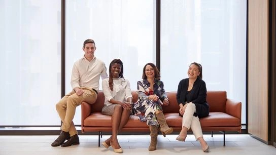 Colleagues seated on a couch, showcasing teamwork and collaboration in a business environment