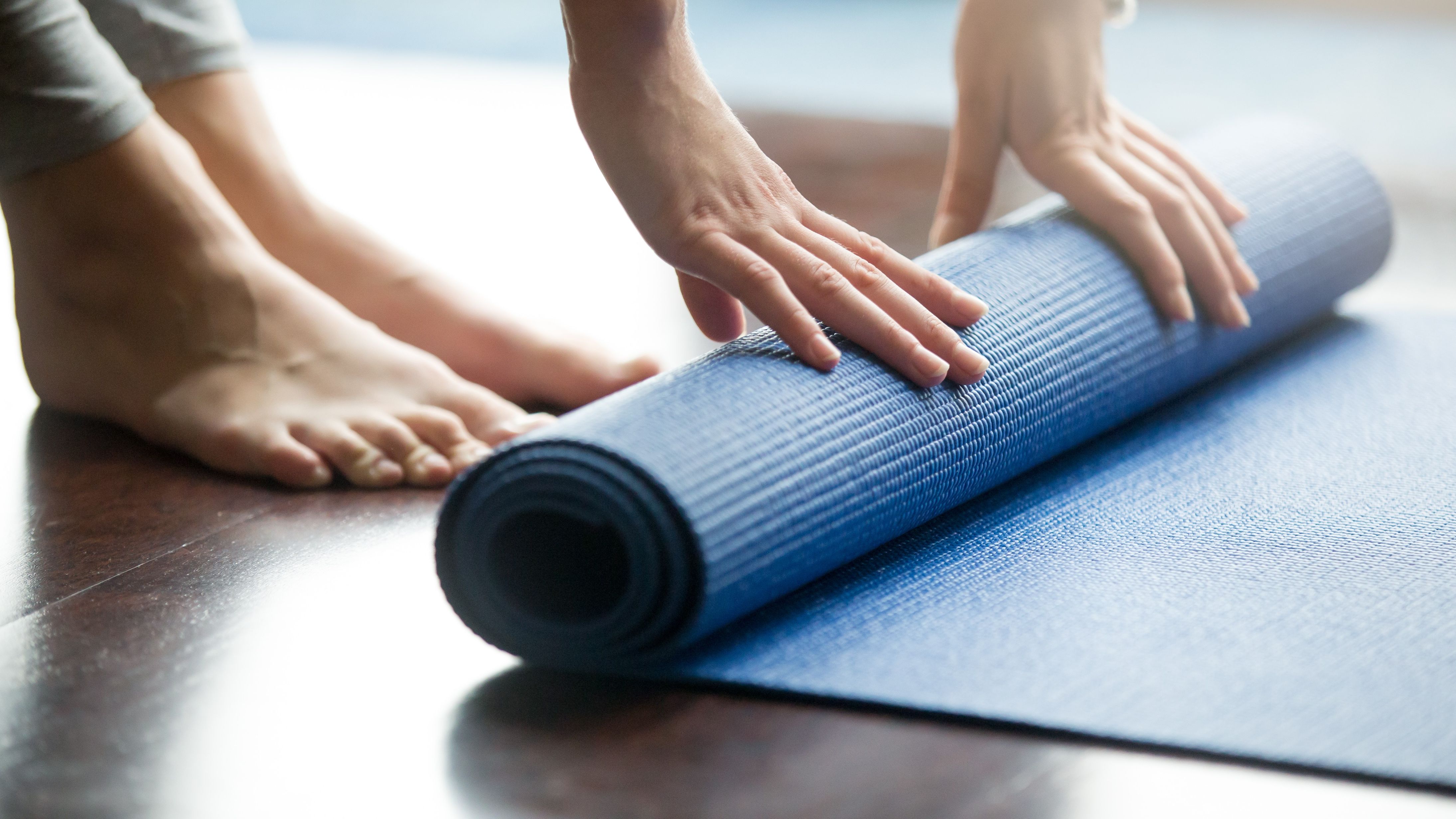Hands rolling a Yoga mat