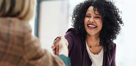 Woman smiling while shaking hands