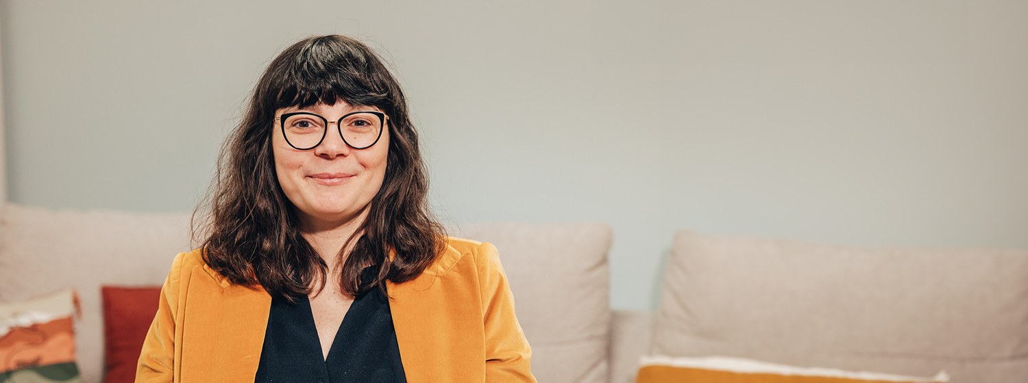 Allianz France Employee sitting on sofa smiling