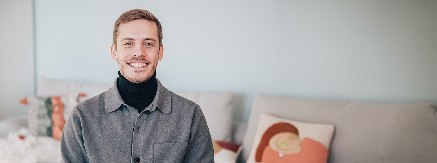 Allianz France Employee sitting on sofa smiling