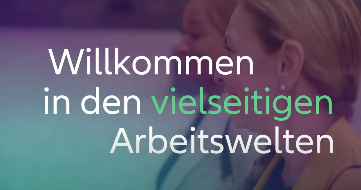 Zwei Frauen im Hintergrund gehen spazieren und im Vordergrund befindet sich der Schriftzug Willkommen in den vielseitigen Arbeitswelten