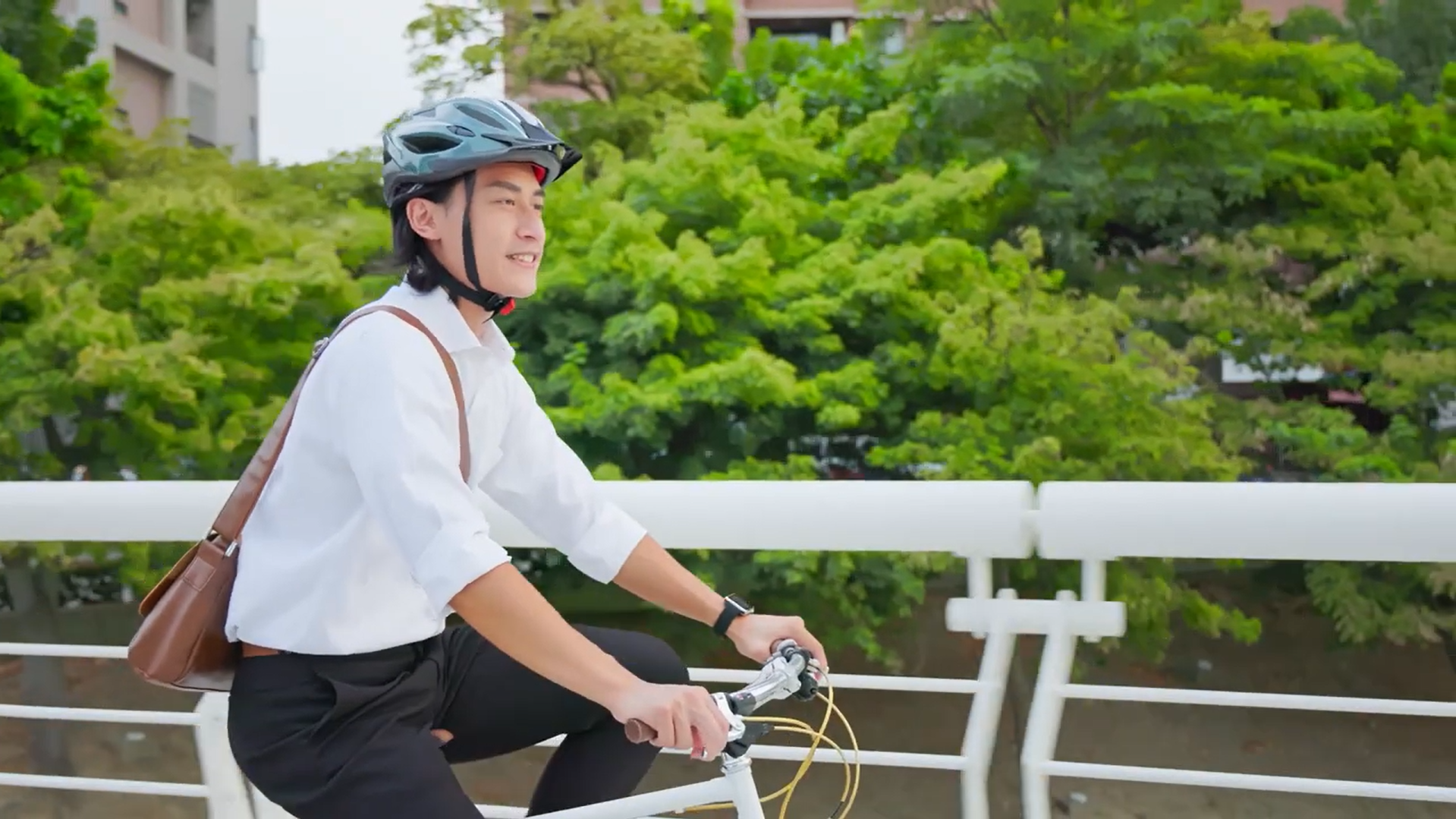 A man riding a bicycle on a road, wearing a helmet