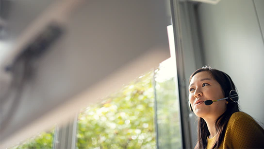 An employee wearing a headset is engaged in a conversation.
