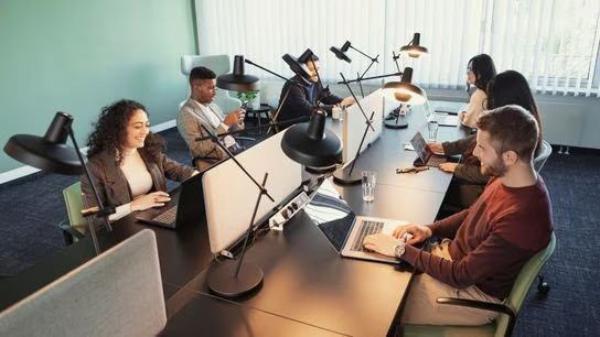 Colleagues working on laptops in a modern office setting