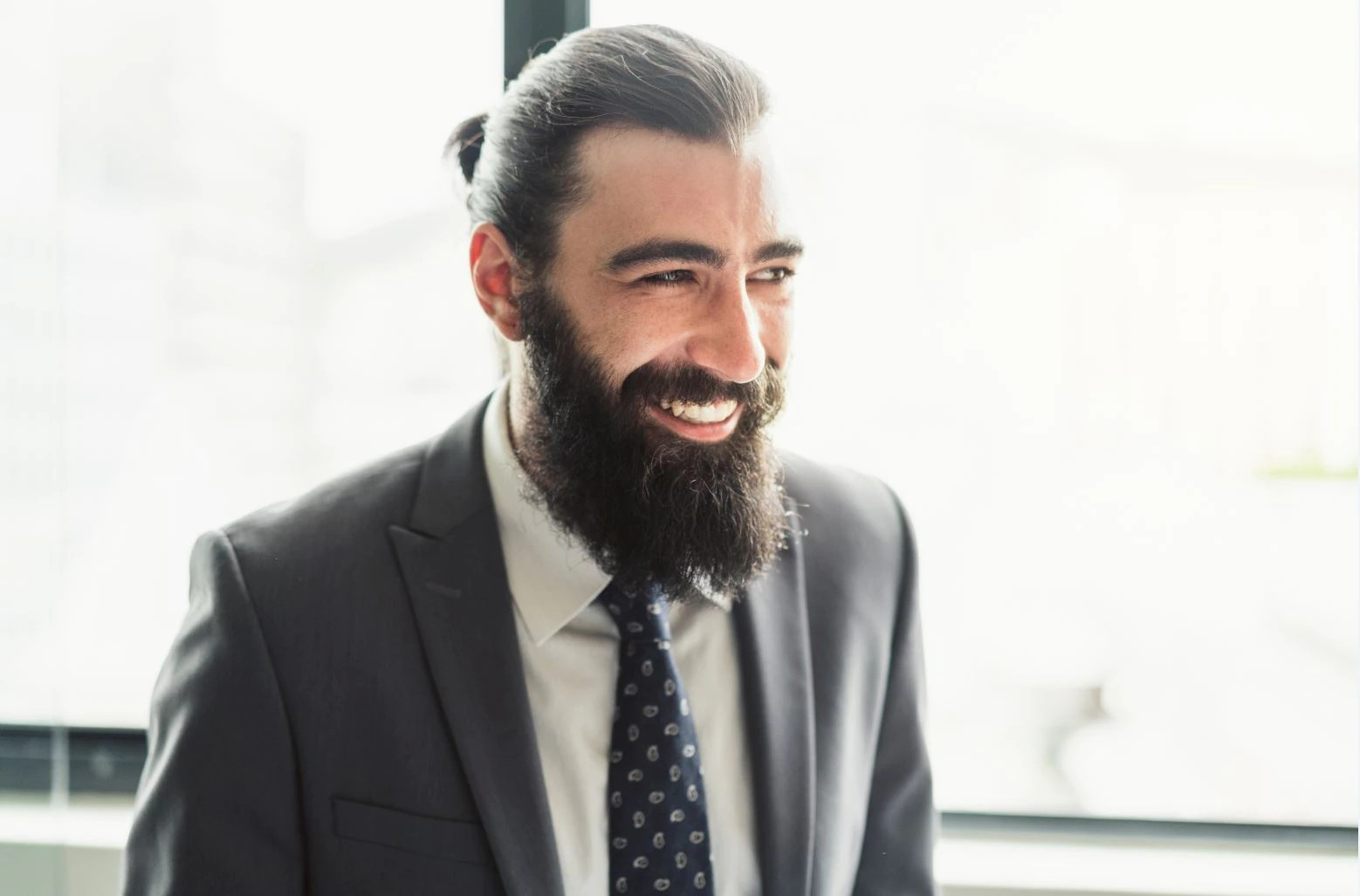 Happy, cheerful businessman in professional attire, laughing and looking away