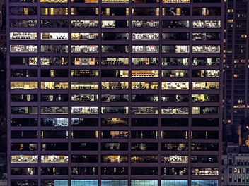 Night view of a glass building illuminated with lights.