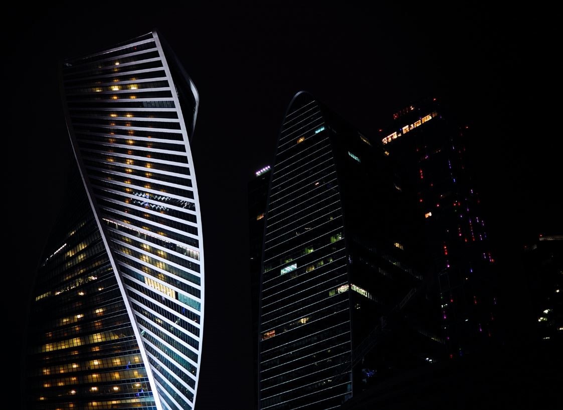 ow-angle view of two modern skyscrapers, featuring a prominent helical twist in its architecture