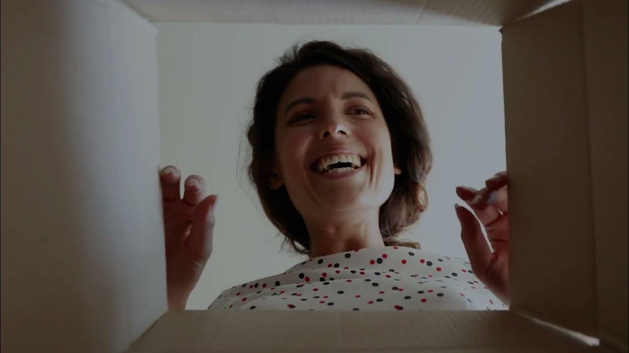 Happy cheerful lady opening a box with excitement