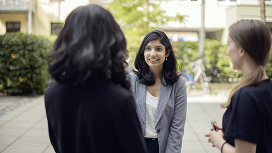 Three colleagues standing outside talking