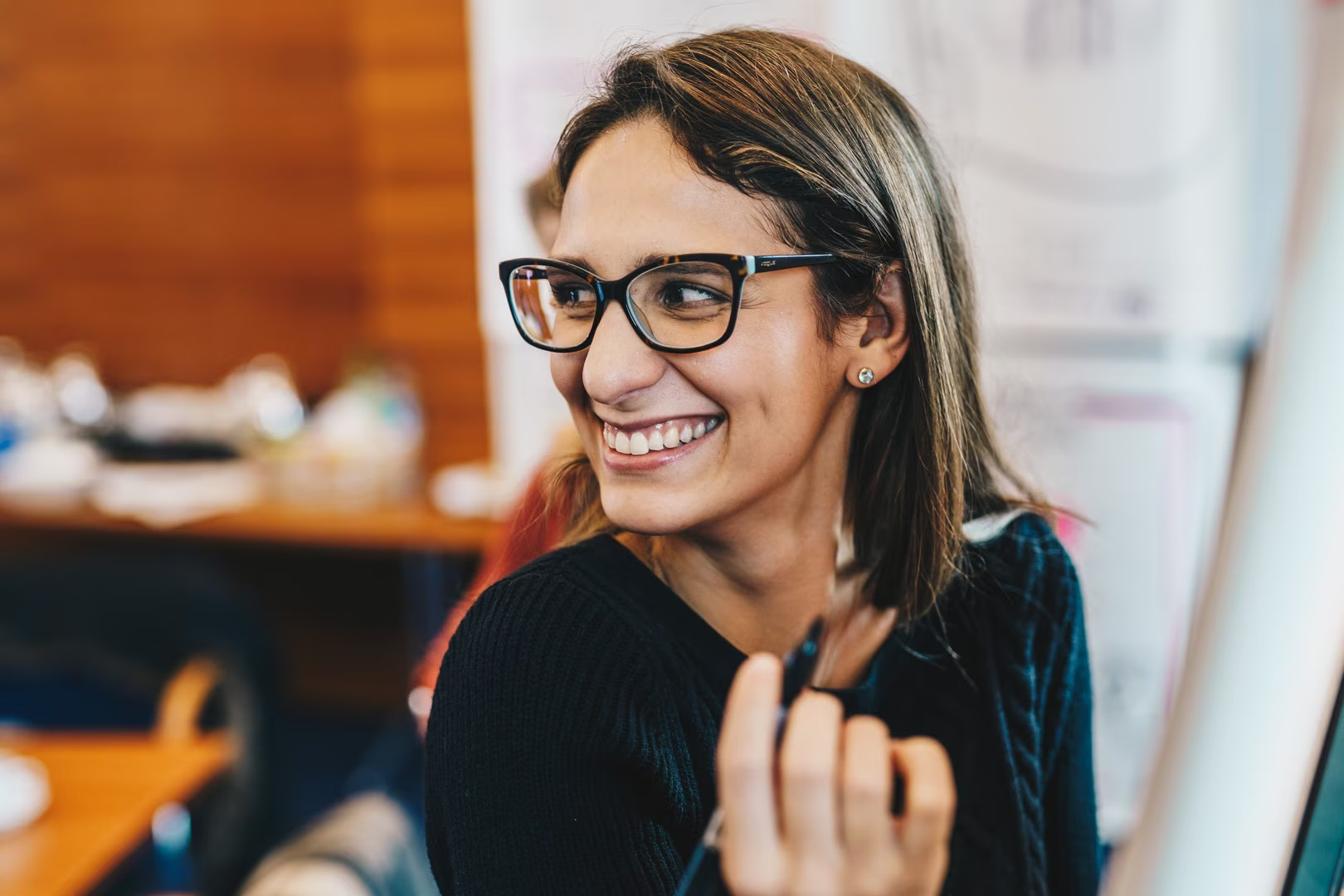 Happy, cheerful woman wearing glasses, laughing and looking away