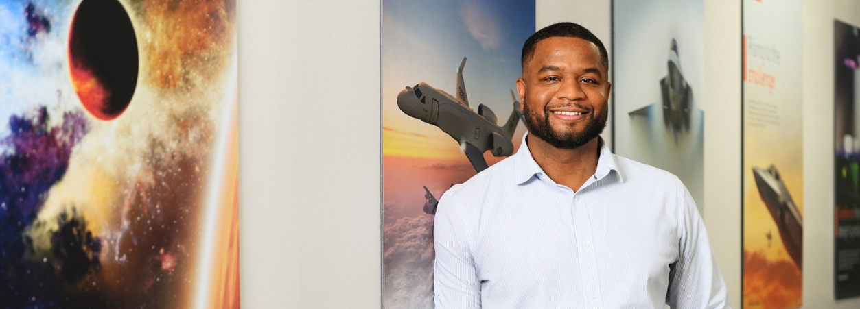 Khalid, a senior CEMA program manager at BAE Systems, smiles for a headshot.