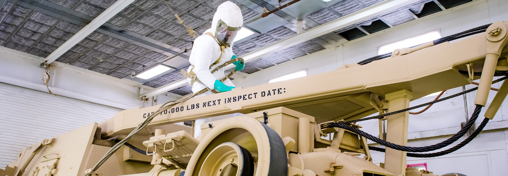 A painter inspeacts a BAE Systems made combat vehicle.