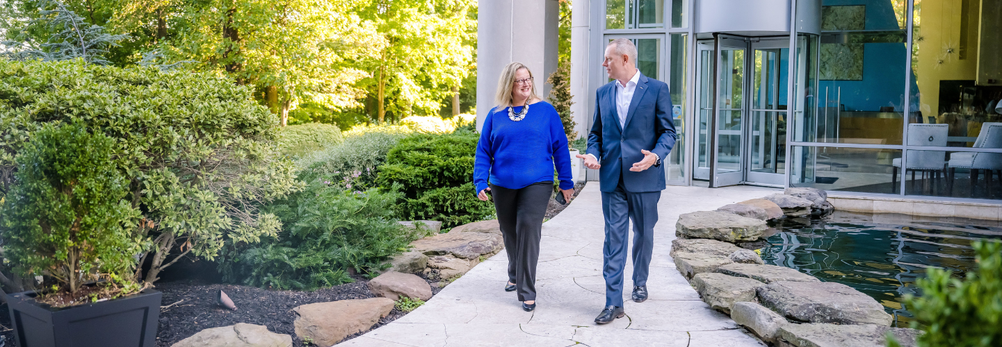 Rachel and Tim, two BAE Systems employees, go for a walk in BAE Systems Falls Church headquarters courtyard. 