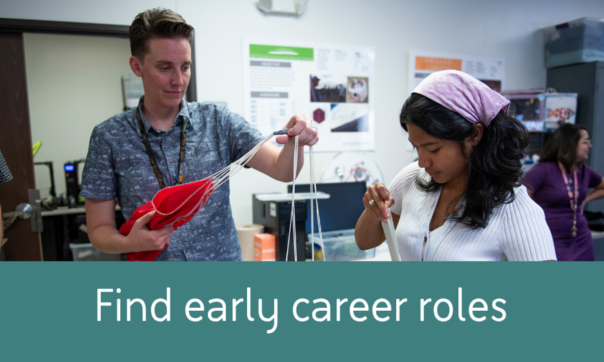 A mentor and early-career professional collaborate on a hands-on project in a lab workspace at BAE Systems.