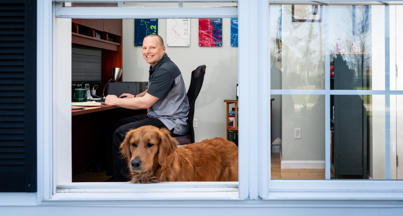 Greg and his dog Luna, in their home office.