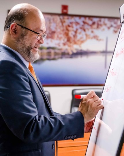 A program manager writes on a white board