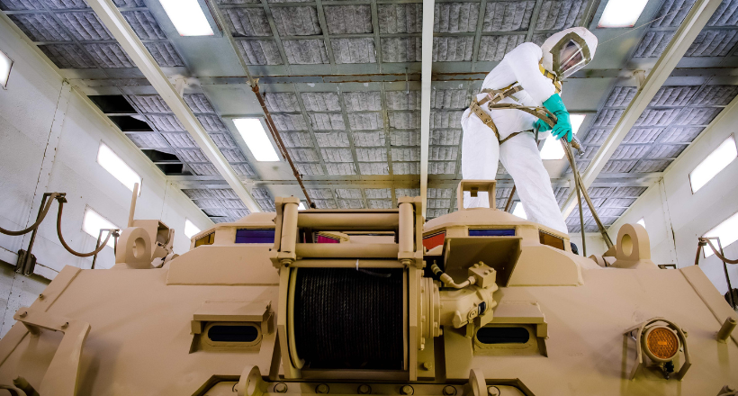 A painter works on a combat vehicle part of our combat mission systems team.