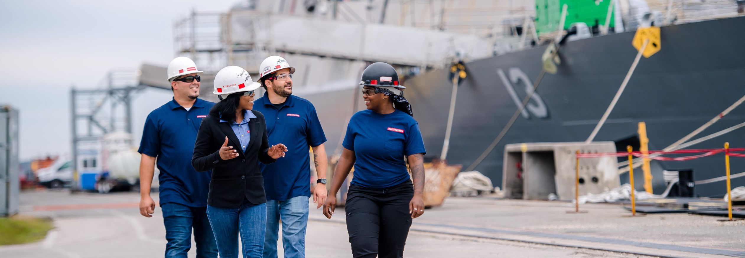 4 BAE Systems employees walk through the shipyard in Jacksonville.