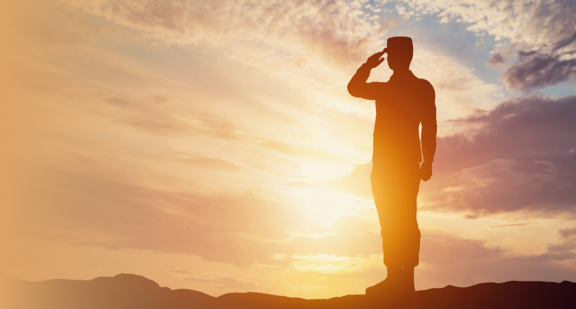 Silhouette of a military service member saluting.