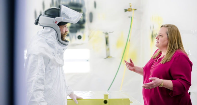 Lexie, a test and manufacturing director for our Space & Mission team, speaks with a painter at a company facility in Boulder.