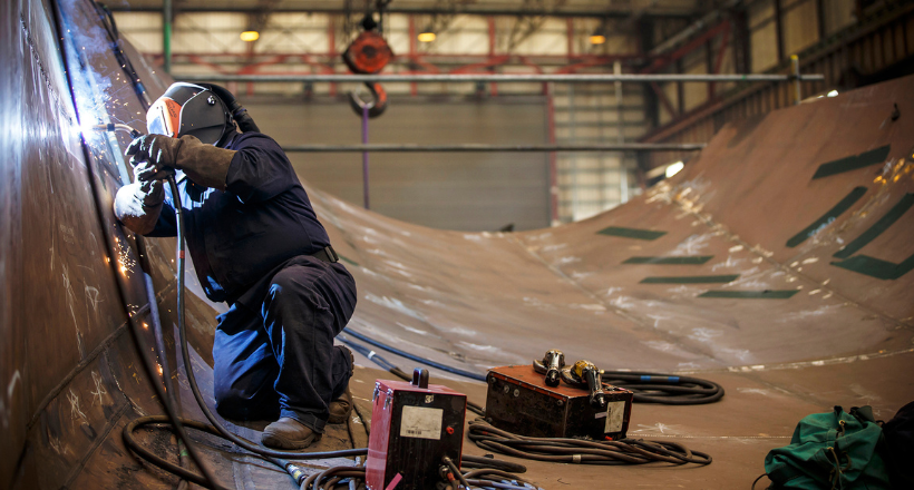 Welder works on a piece of a vessel at one of BAE Systems maritime solution facilities.