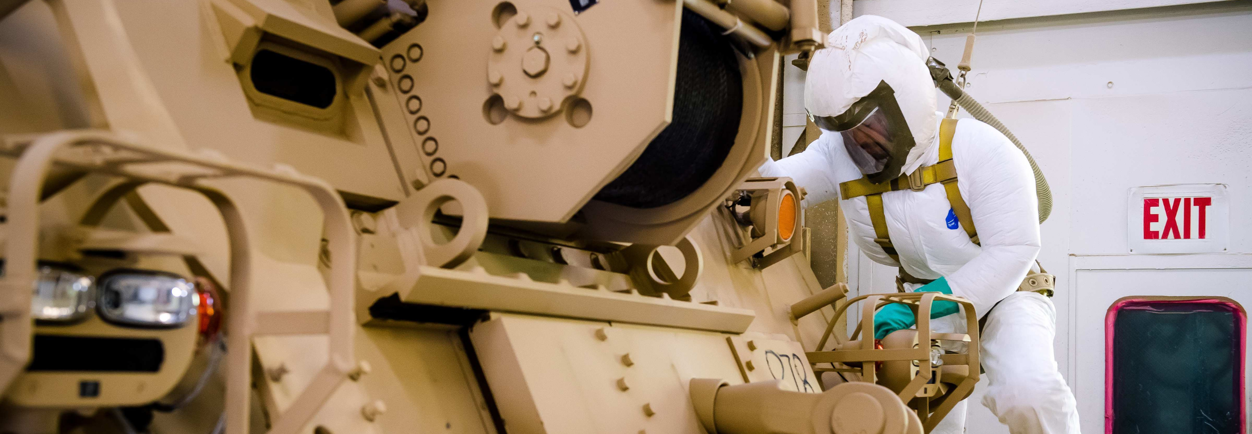Painter working on a combat vehicle.