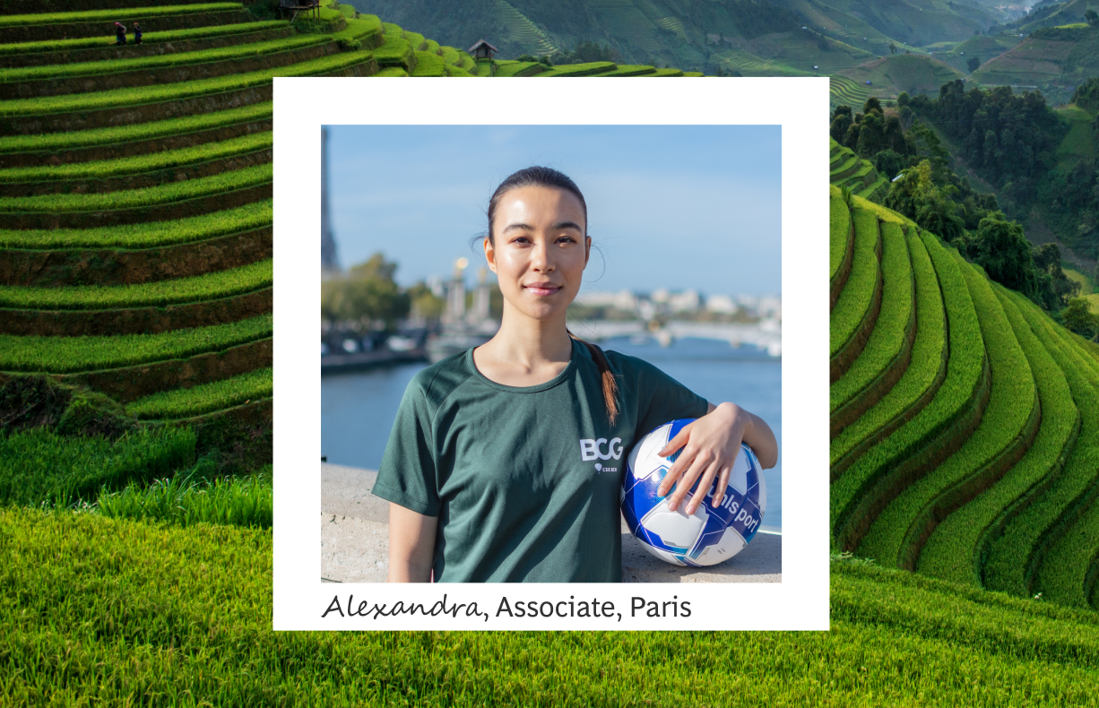 The image features Alexandra, an associate in Paris, confidently holding a volleyball against a stunning backdrop of vibrant green rice terraces. She is dressed in a casual BCG-branded t-shirt, with a calm and focused expression, emphasizing a balance between professional commitment and personal well-being. The lush terraced fields in the background symbolize growth and sustainability, aligning with the themes of teamwork and environmental consciousness. 