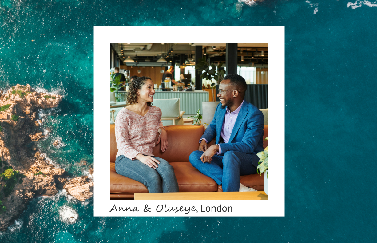 The image depicts Anna and Oluseye, identified as being in London, framed within a white border. Anna is dressed in a pink sweater and jeans and Oluseye is in a blue suit. They are sitting on a brown sofa in a modern office environment engaged in conversation. In the background behind the frame is an overhead view of a teal blue ocean and part of a rocky coastline. 